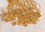pile of 18k gold plated stainless steel letter pendants on marble